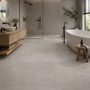 Botticelli Grigio 100 x 100 cm natuursteenlook vloertegel in badkamer met douche en bad